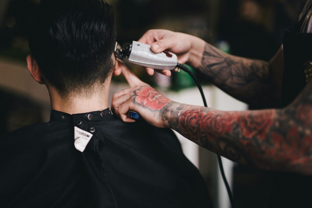 Barber werkt een fade bij met een tondeuse